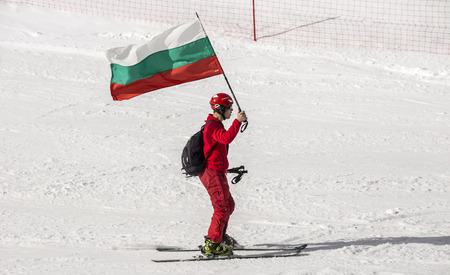 PAMPOROVO, BULGARIA - MARCH 03, 2017 - Skiing with Bulgarian flags at Pamporovo, Bulgaria. People dressed with traditional bulgarian clothes skiing with the national flag.のeditorial素材