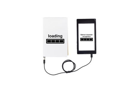 Book connected to a tablet through an USB cable. Optical character recognition loading bar.の写真素材