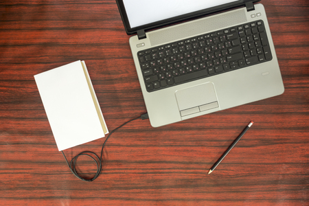 Data transfer concept. Book and a laptop connected with USB cable.の写真素材