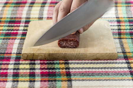 Cutting traditional Bulgarian flat sausage called lukankaの写真素材