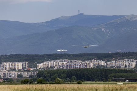 Motorless sailplane towed by another aircraft over a cityの写真素材