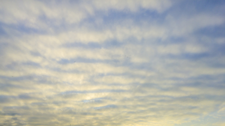 Beautiful wavy pattern clouds in the sky during sunsetの写真素材