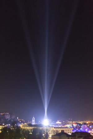 Alien spaceship landing in a city enviroment. UFO concept with bright light beams in the sky.の写真素材