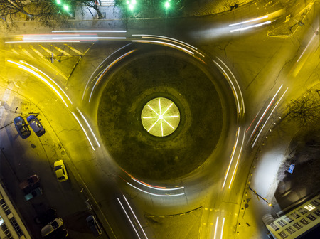 Aerial view of a roundabout at night. Many car trails show busy city streets.の写真素材