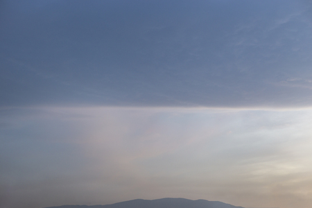Straight line cloud spliting the sky in half. Rectangle square shaped cloud.の写真素材