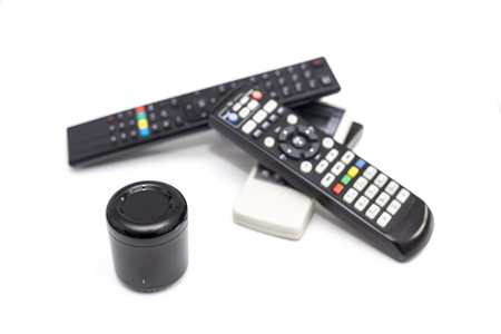 Universal ir and wifi remote with voice activation next to old fashioned remotes with buttons isolated on white background.の写真素材