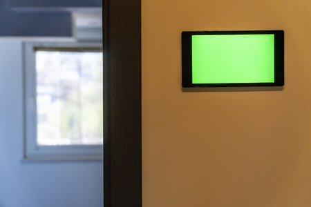Home automation concept. Device with blank screen hanging on a wall.の写真素材