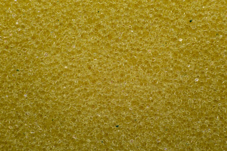Extreme macro shot of a yellow dish wash sponge showing the structure of the material.の写真素材