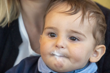 Very cute baby boy with milk mustache smiling at the camera.の写真素材