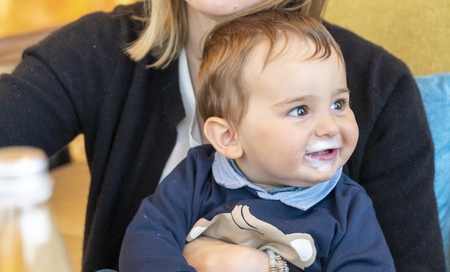 Very cute baby boy with milk mustache smiling at the camera.の写真素材