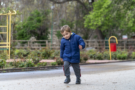 Young boy running around in an outdoor parkの写真素材