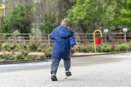 Young boy running around in an outdoor parkの写真素材