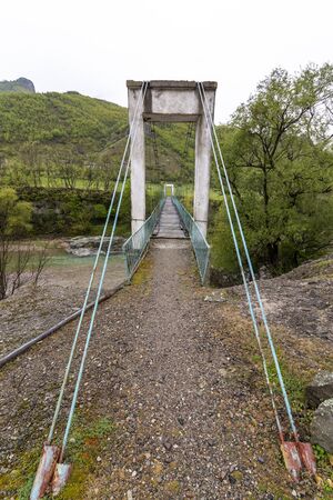 Very old and rusty suspension bridge over Borovitsa river in the Rhodope mountain in Bulgariaの写真素材