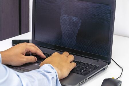 Developer coding on a laptop and creating a artificial intelligence software. Human like face made...