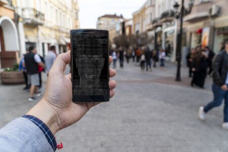 Smartphone AI concept. Using AI bot on a cellphone on the city streetsの写真素材