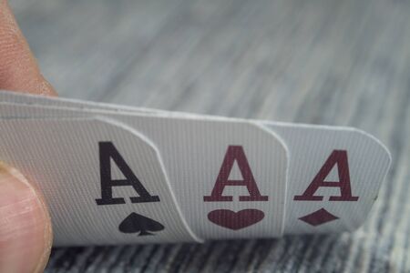 Low angle closeup view of a male hand picking up and showing cards from a casino tableの写真素材
