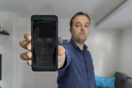 Man shwing smartphone to the camera with AI bot face on the screenの写真素材