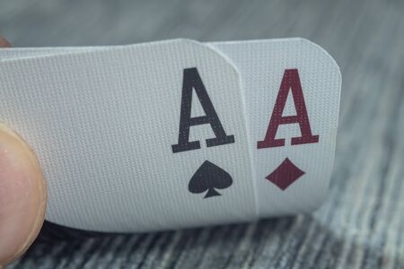 Low angle closeup view of a male hand picking up and showing cards from a casino tableの写真素材