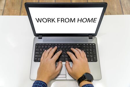 Overhead view of a person working on a laptop with work from home message on the screenの写真素材