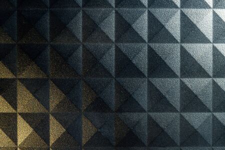 Pyramid pattern background with a rough surface and contrasting lightの写真素材