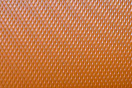 Extreme macro of an orange plastic suitcase cover patternの写真素材