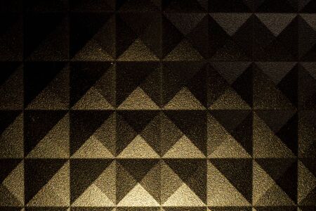 Pyramid pattern background with a rough surface and contrasting lightの写真素材