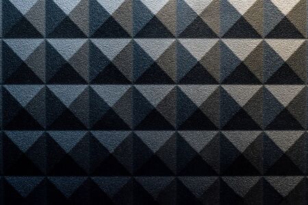 Pyramid pattern background with a rough surface and contrasting lightの写真素材