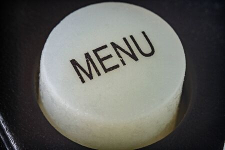 Extreme macro shot of a white menu buttin on a TV remote controlの写真素材