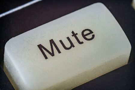 Extreme macro shot of a white mute button on a TV remoteの写真素材