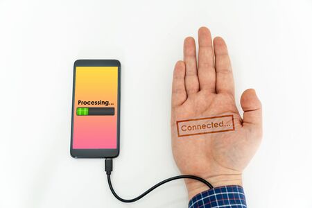 Augmented human hand connected to a smartphone via usb cable and transferring data. Hologram notification appearing on the handの写真素材