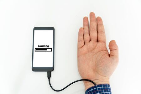Augmented human hand connected to a smartphone via usb cable and transferring data. Hologram notification appearing on the handの写真素材