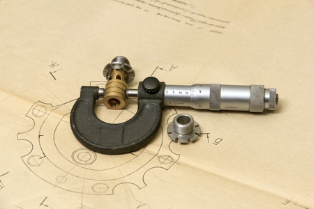 Measuring tools (micrometer) and metal details lying in the drawing.の写真素材