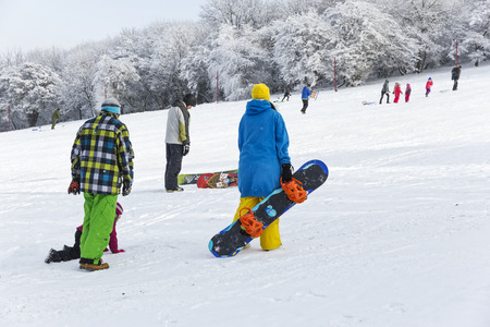 Pyatigorsk, Russia -January 02, 2016: Adults and children sledding and snowboarding on the slope of the mountains in winter sunny day.のeditorial素材