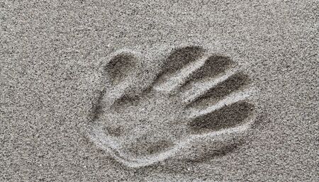 The imprint of a man's hand on the sand.の写真素材