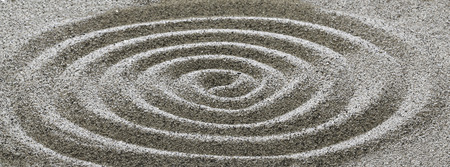 Drawing on the sand in a spiral.の写真素材