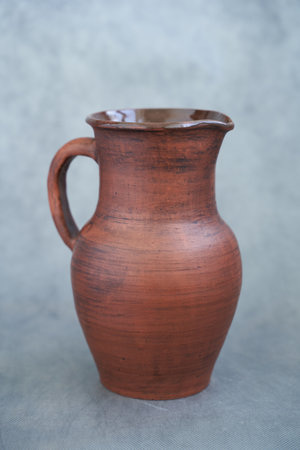 Clay jug on a gray background. Side view Copy space.の写真素材