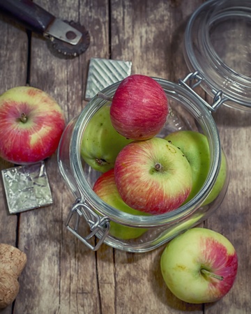 few ripe apples in a glass jarの写真素材