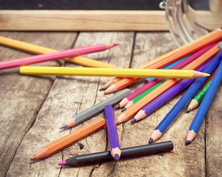 Pencils of different paints scattered on a tableの写真素材