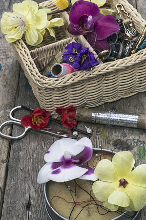 buttons,threads in wicker basket decorated with flowersの写真素材