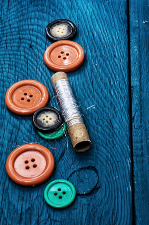 set of threads and buttons on the background of woodの写真素材