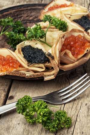 delicious pancakes stuffed with red and black caviarの写真素材