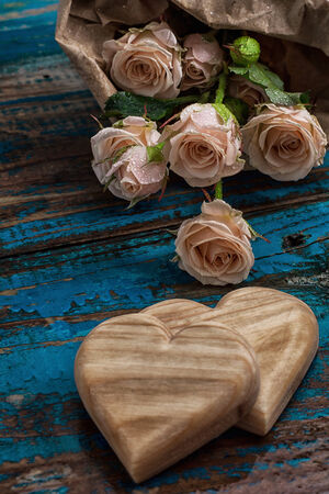 two wooden heart and bouquet of fresh cut rosesの写真素材
