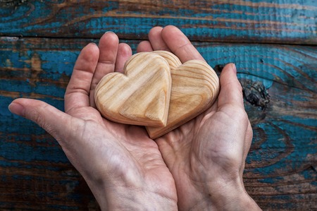 two symbolic wooden heart in your handsの写真素材