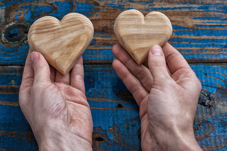 two symbolic wooden heart in your handsの写真素材