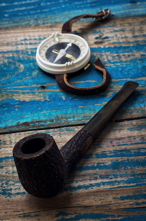 nautical compass with pipe on wooden surfaceの写真素材