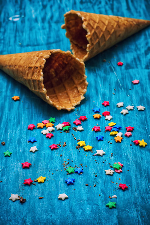 two empty waffle cone for ice cream on wooden turquoise backgroundの写真素材