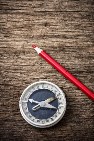 obsolete compass on wooden table top in retro styleの写真素材