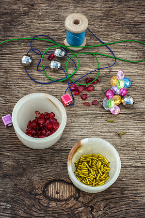 set of beads in stacks on wooden table with tools for needlework.Selective focus.Photo tintedの写真素材