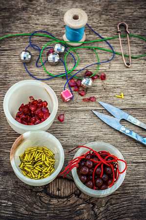 set of beads in stacks on wooden table with tools for needlework.Selective focus.Photo tintedの写真素材