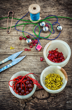set of beads in stacks on wooden table with tools for needlework.Selective focus.Photo tintedの写真素材